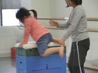 跳び箱によじ登る少女