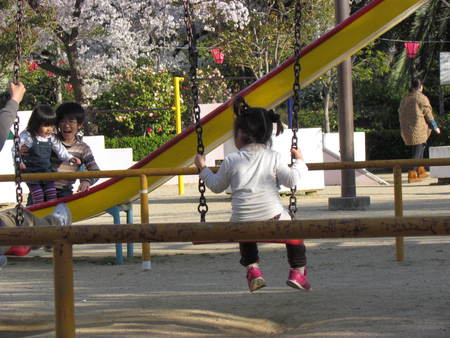 サクラ花と子供の遊ぶ公園　　　おおさかにて