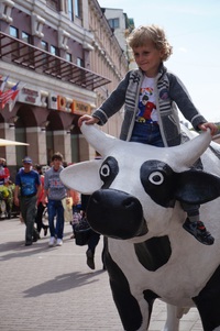ムウムウの宣伝の牛に乗る子供